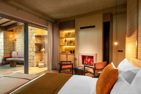 Corner Suite — Taş terasla bağlantılı şömineli iç mekân