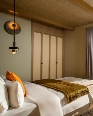 Corner Suite — Yatak odasında ahşap dokular ve doğal ışık
